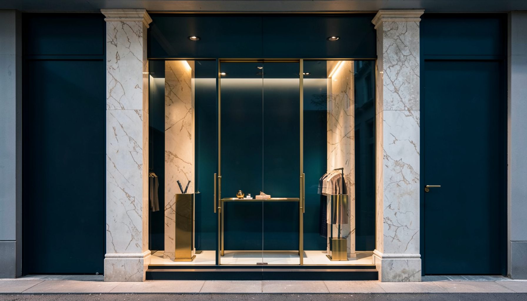 Clean architectural photograph of a luxury boutique window display, with symmetrical marble columns, soft warm lighting