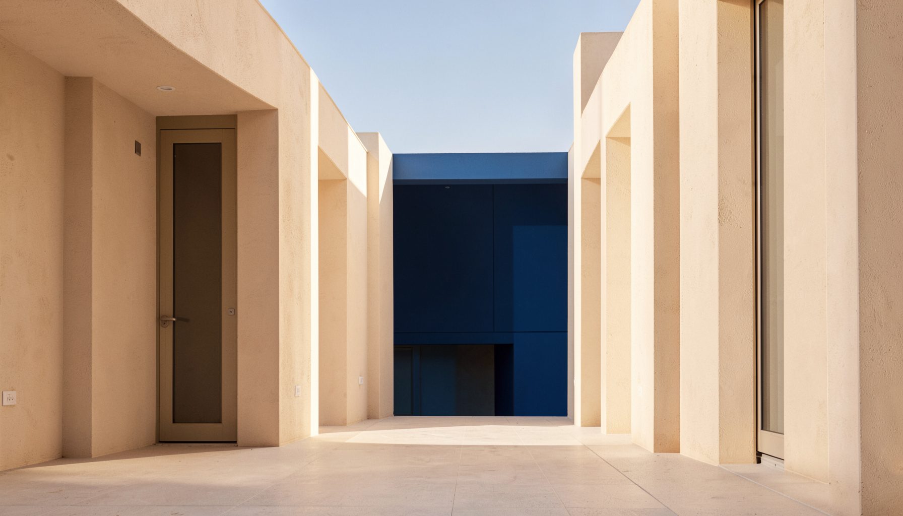 A clean, symmetrical architectural photograph with warm beige tones and soft natural light, conveying a calm and inviting atmosphere